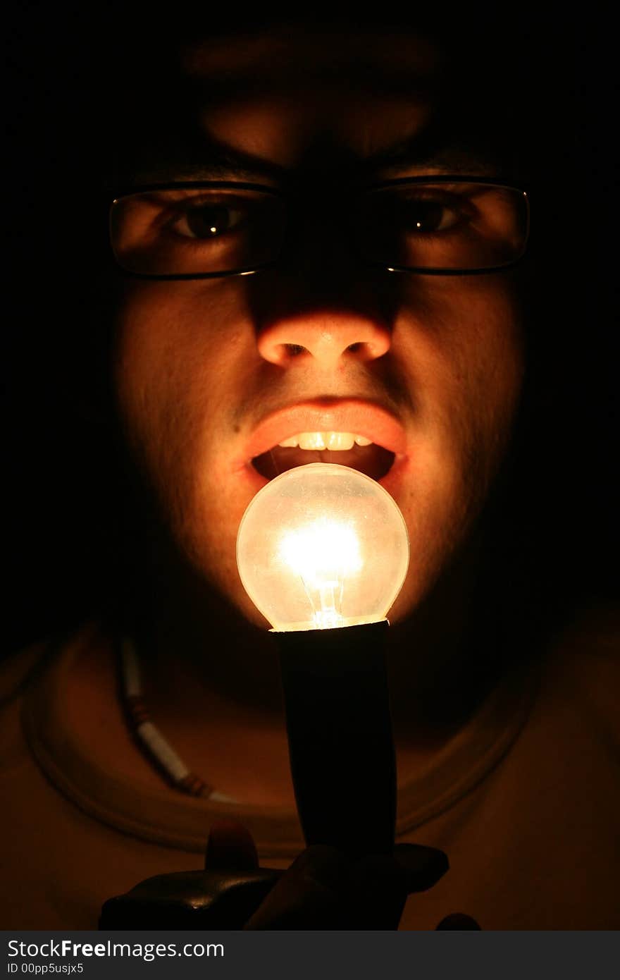 Guy in the dark whit light in front of his mouth. Guy in the dark whit light in front of his mouth