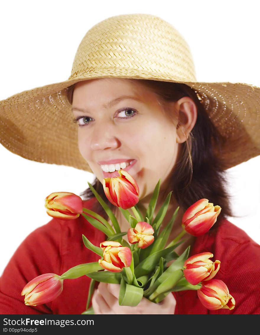 Young woman with strawhat and a bunch of tulips, focus on tulips. Young woman with strawhat and a bunch of tulips, focus on tulips