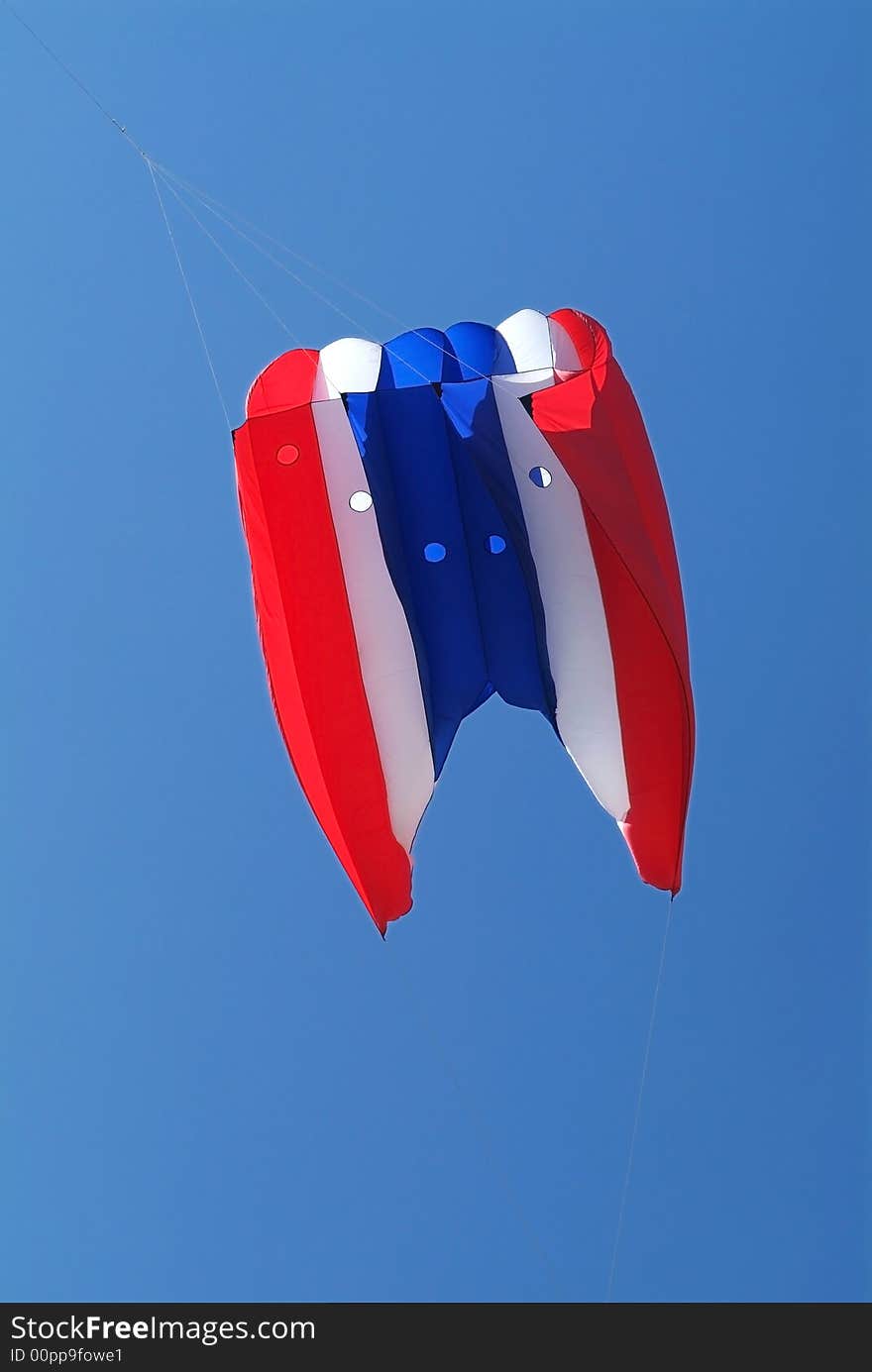 Red, white and blue kite on a blue sky background. Red, white and blue kite on a blue sky background