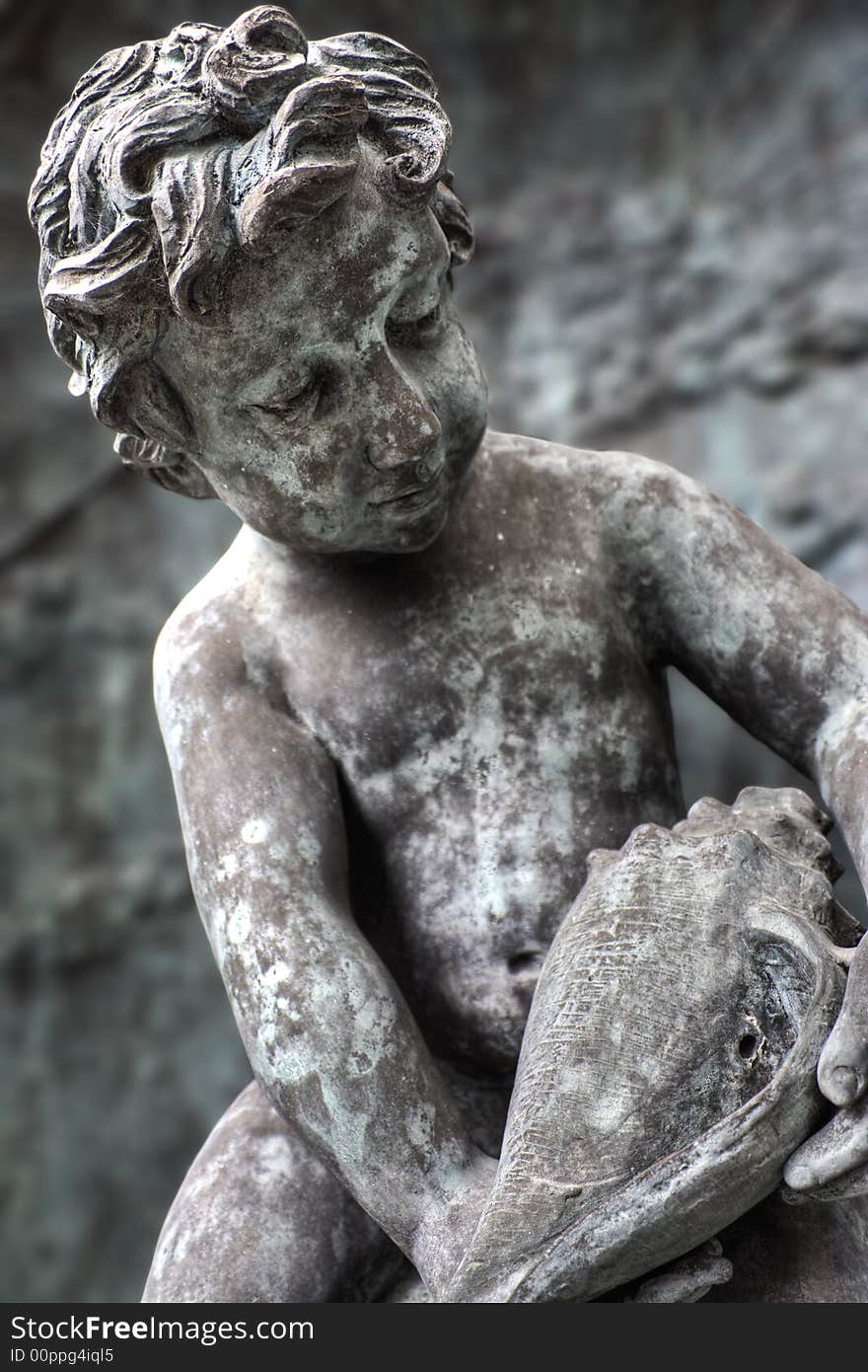 Statue of boy looking at seashell