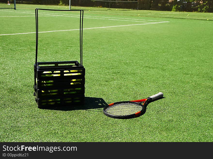 Tennis racket and tennis balls on a court