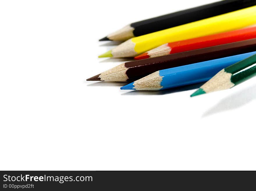 Six coloured pencils over white background