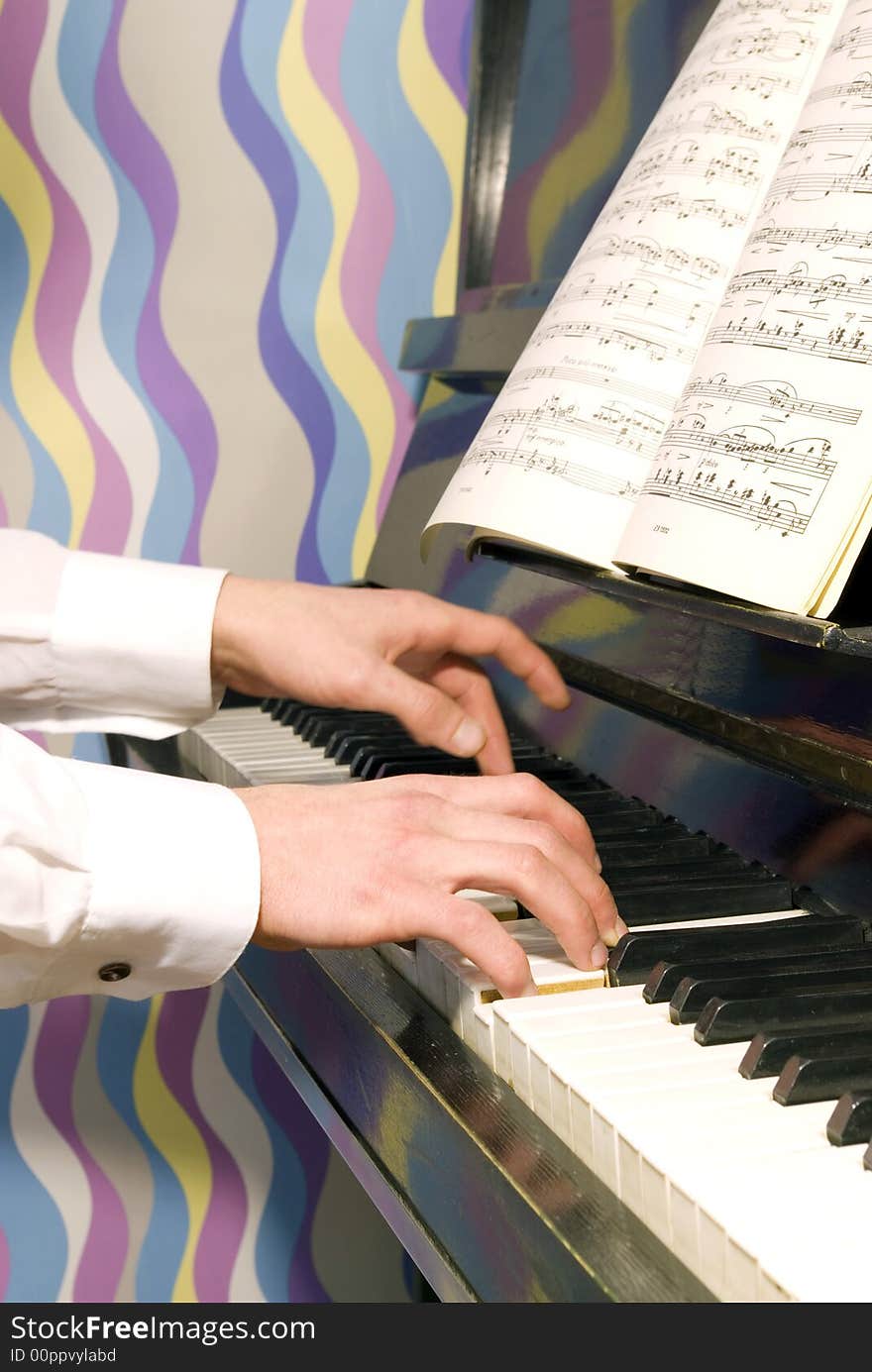 A closeup of a pair of hands playing a piano.