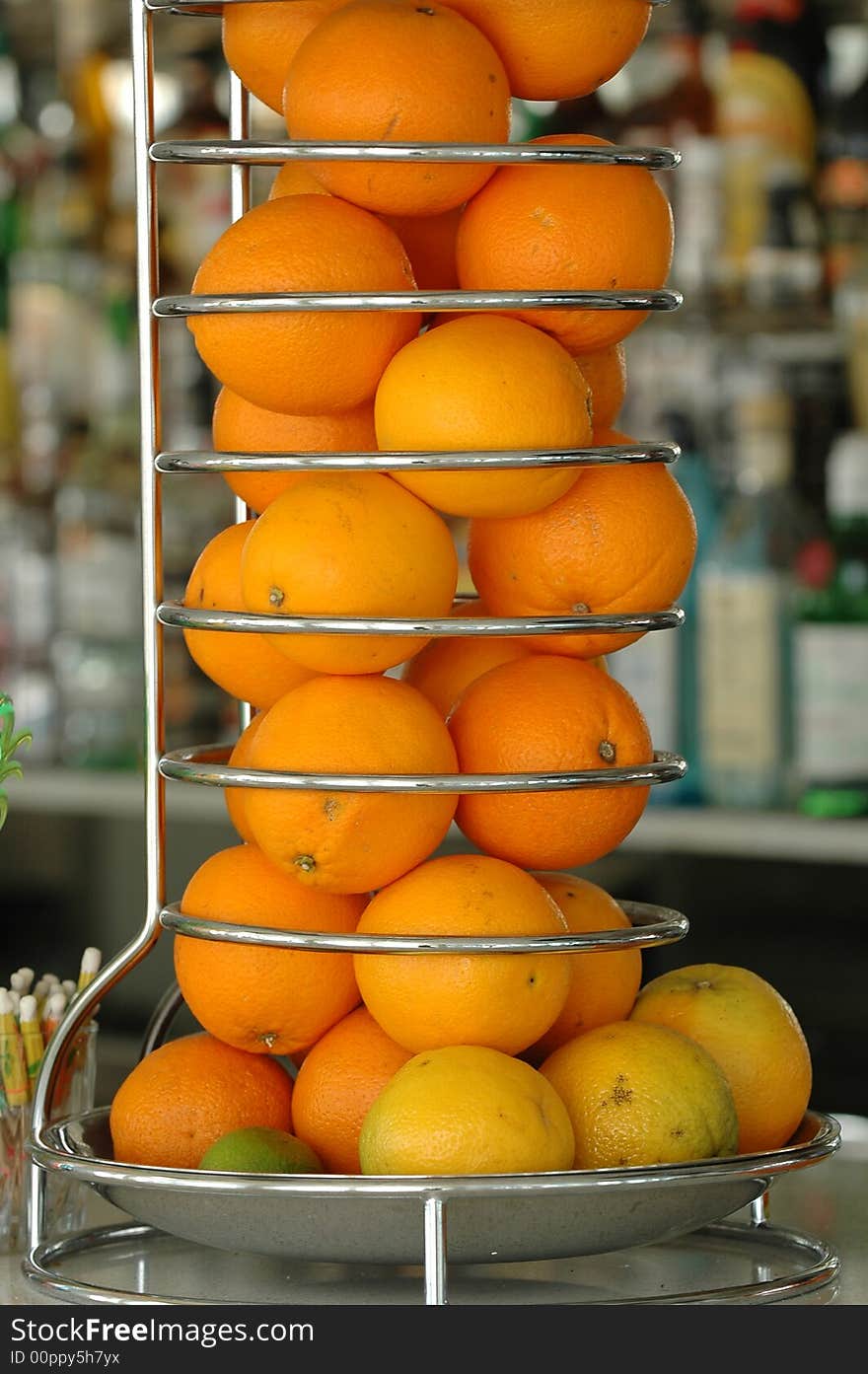 Many oranges in a special container at a bar counter. Many oranges in a special container at a bar counter