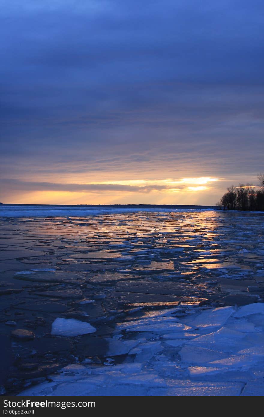 The sun sets over Three Mile Bay casting a light glow over the broken ice during a warm January thaw. The sun sets over Three Mile Bay casting a light glow over the broken ice during a warm January thaw.