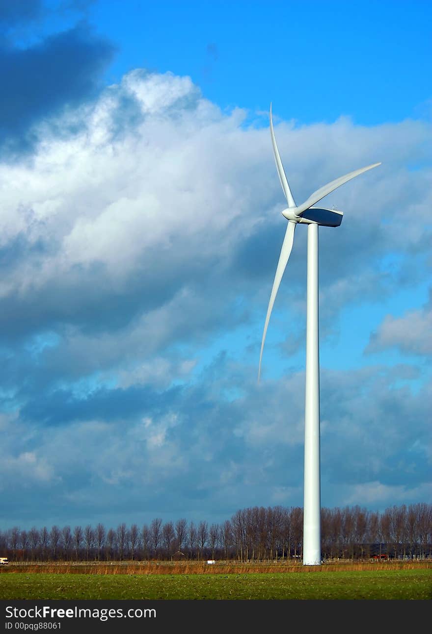 Wind Turbines in the grass with blue cloudy sky