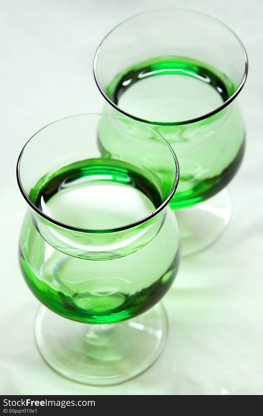 A photo of two green glasses. A photo of two green glasses