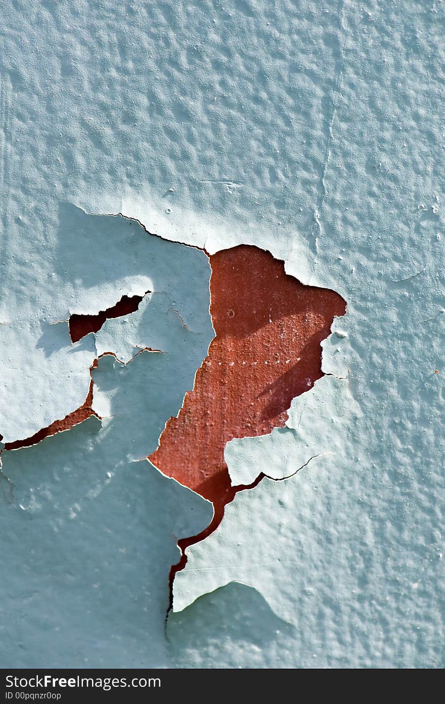 Close up of a red wall with green colored paint that is cracking. Close up of a red wall with green colored paint that is cracking