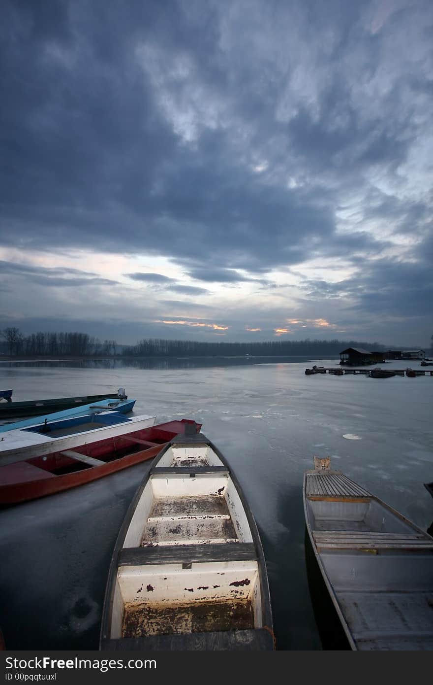 Old boat on frozen river Danube in january