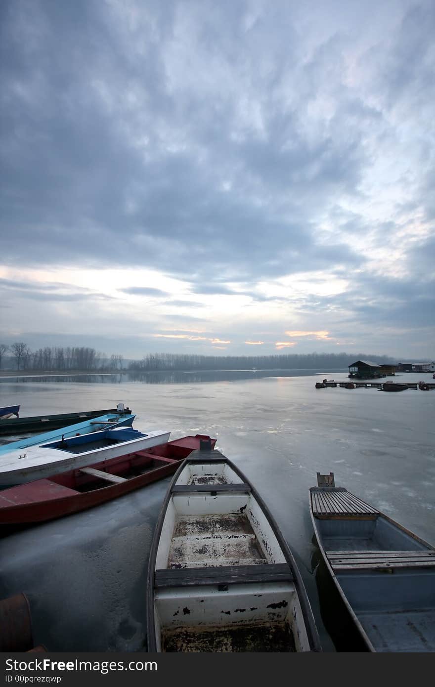 Old boat on frozen river Danube in january