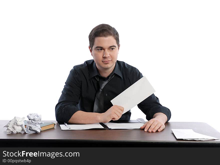 Business man sitting at desk tossing up paper. Business man sitting at desk tossing up paper