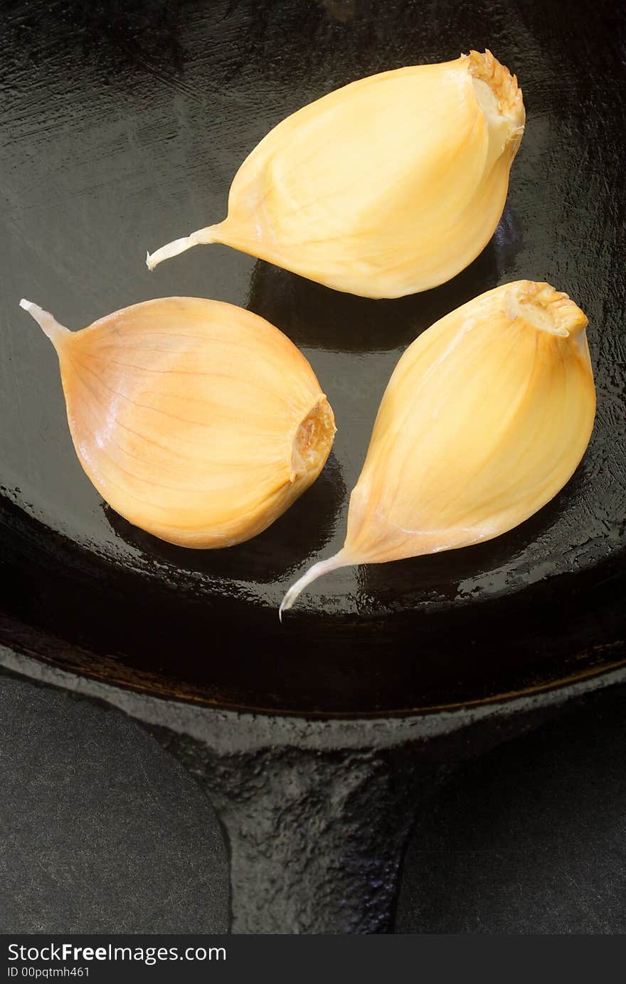 Cloves of garlic in a cast iron skillet.