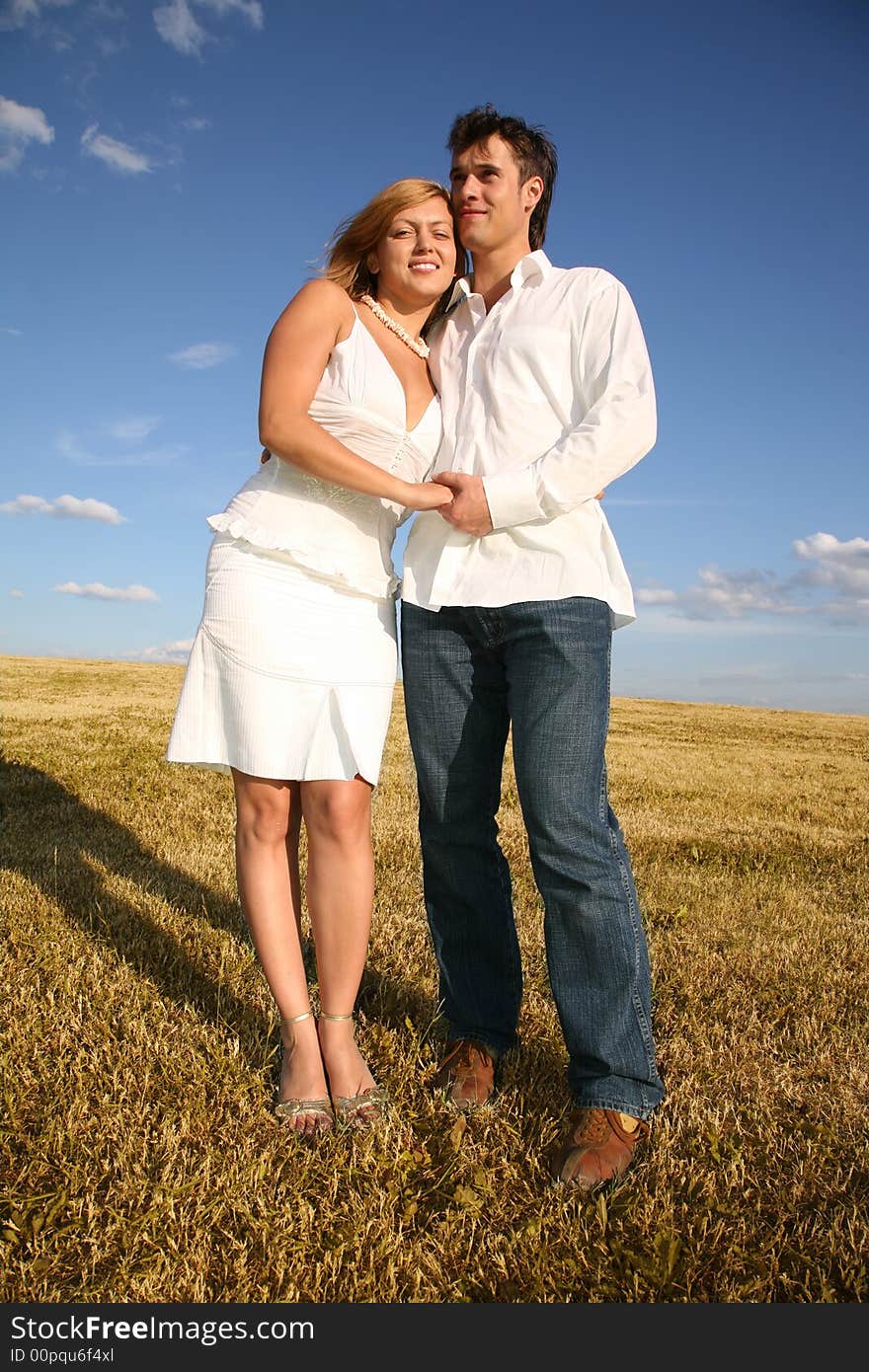 The couple stand on meadow