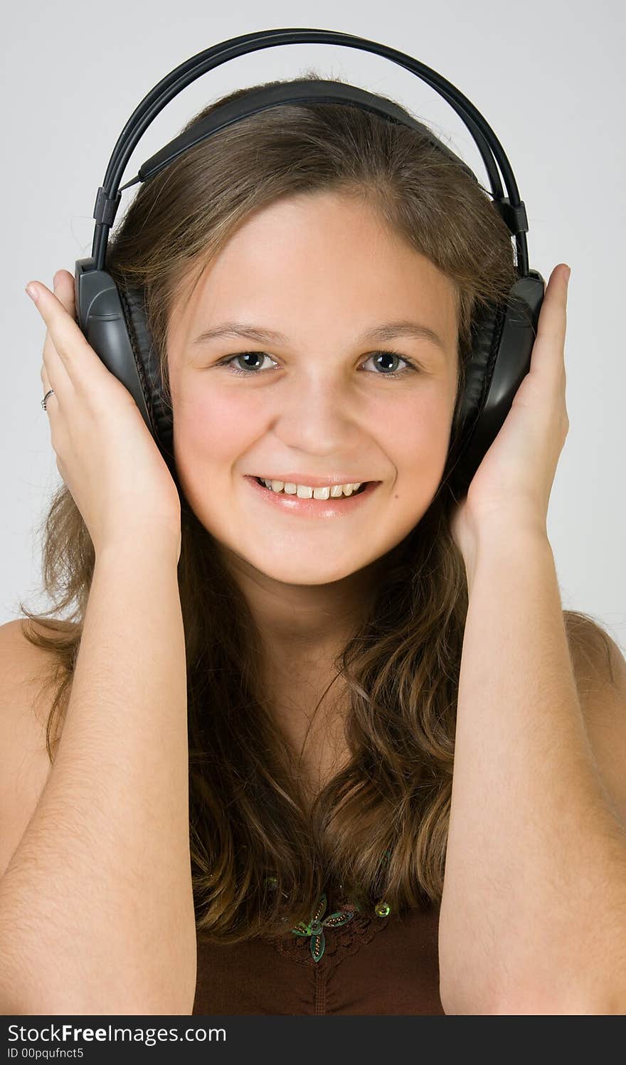 Young pretty smiling girl listening music with headphones