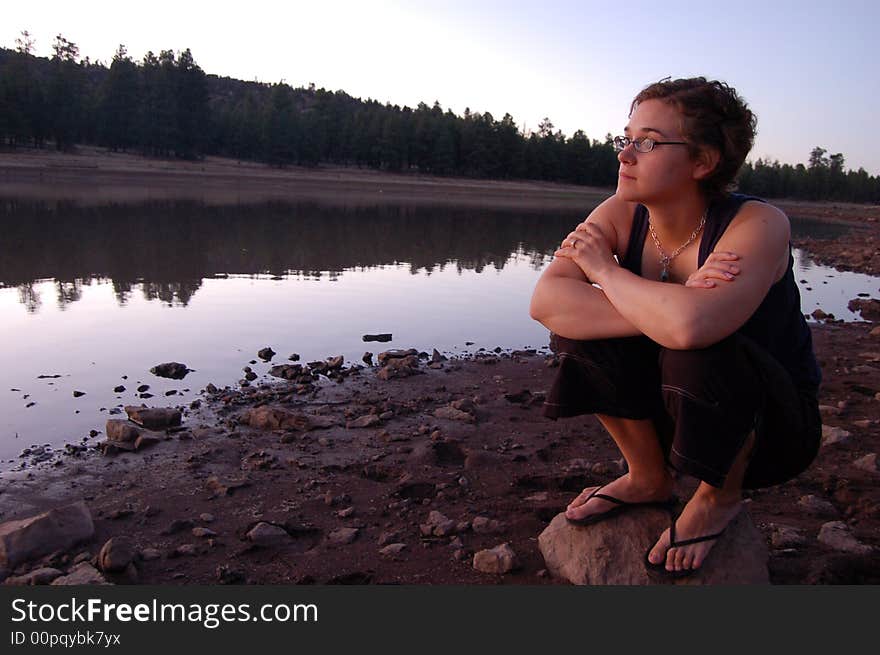 Woman watches sunset near water. Woman watches sunset near water