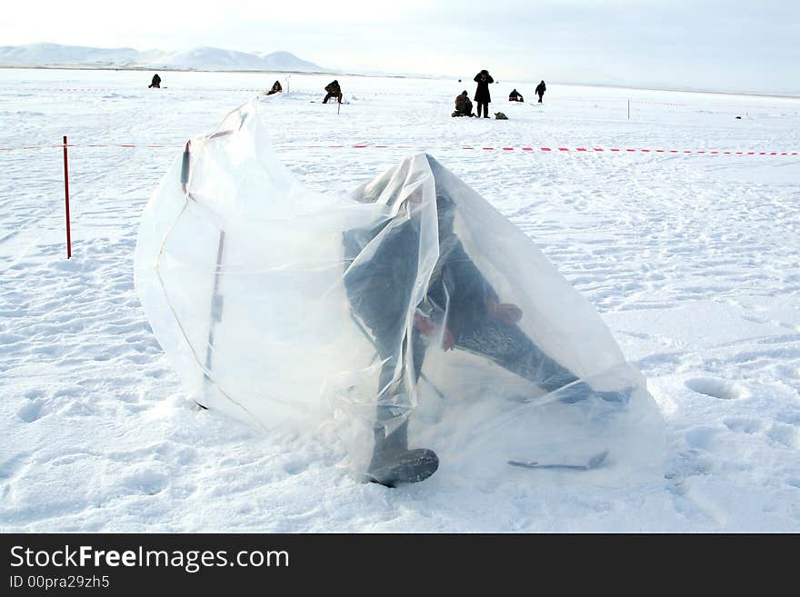 Fishing on an ice of the frozen lake. Fishing on an ice of the frozen lake