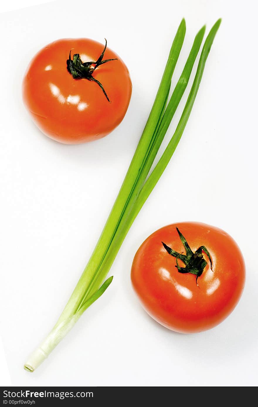 Red tomatoes and green onions, are located in the form of a sign percent. Red tomatoes and green onions, are located in the form of a sign percent