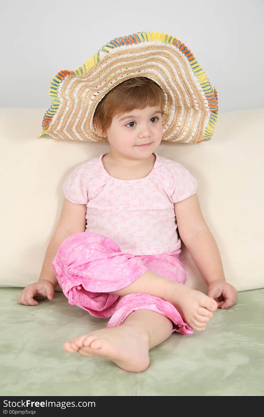 Girl on sofa in straw hat. Girl on sofa in straw hat