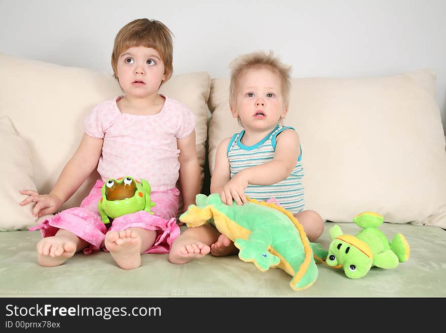 Two children on sofa with toys. Two children on sofa with toys