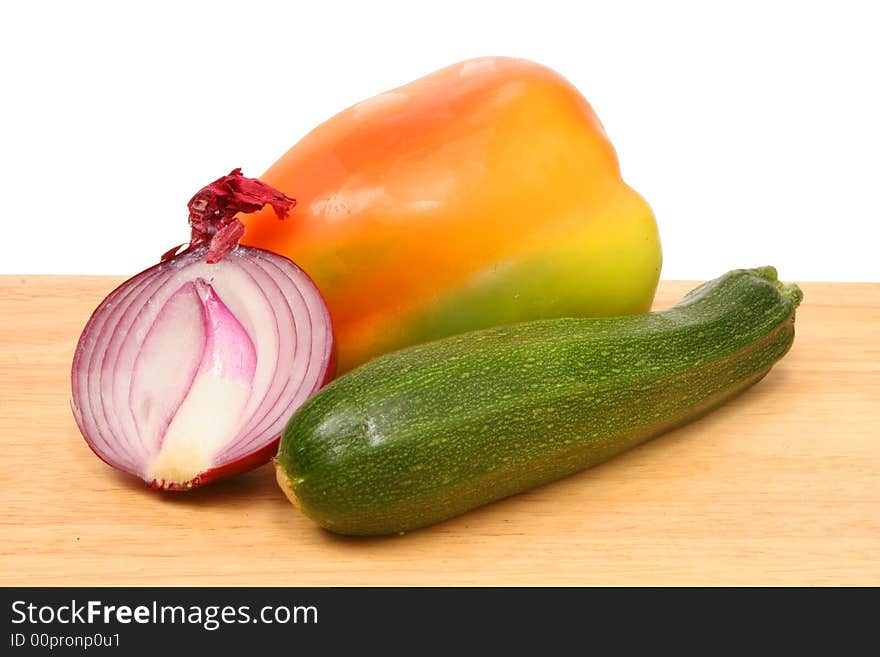 Onion,courgette and pepper on wooden board. Onion,courgette and pepper on wooden board