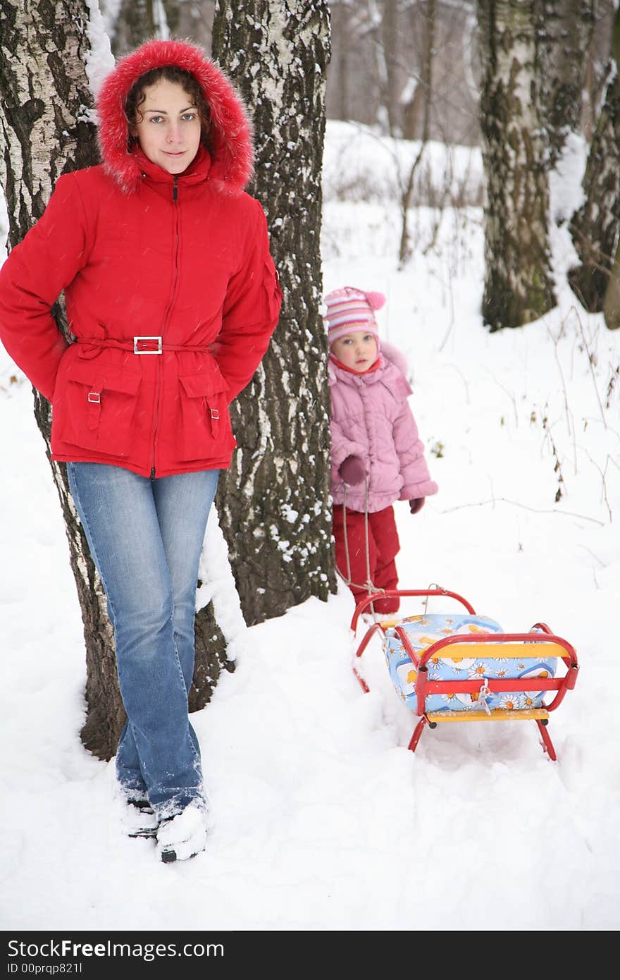 Mother and child stand in park at winter