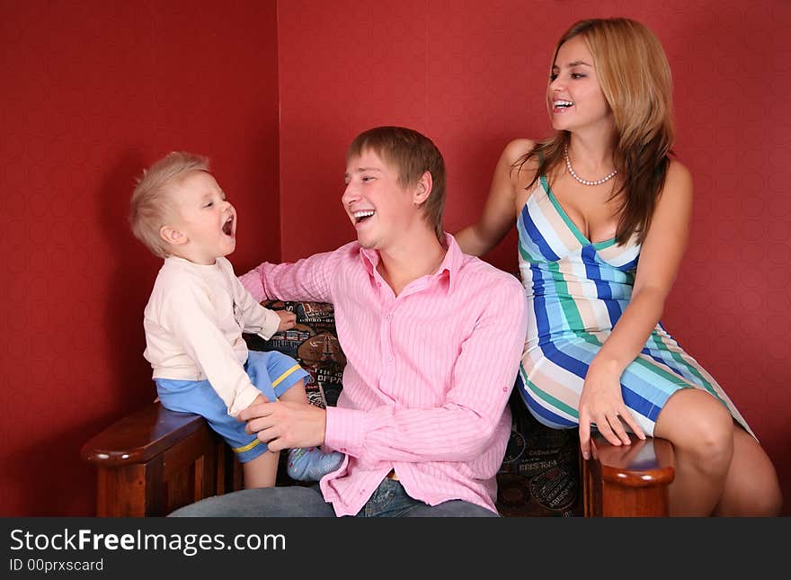 Young family laughing in red room