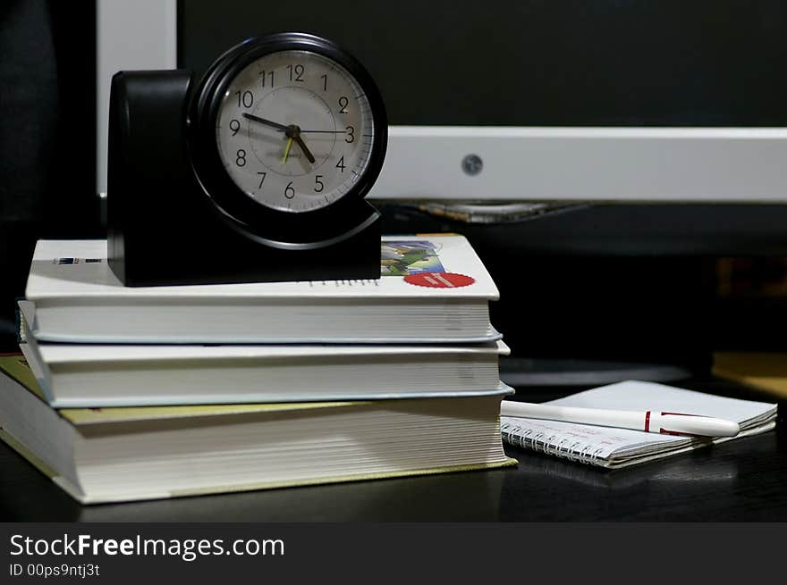 Objects on the working table: the book, hours, computer, notebook, etc. Objects on the working table: the book, hours, computer, notebook, etc.