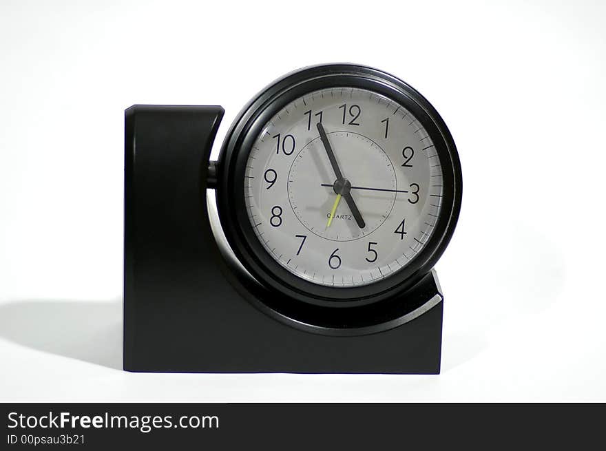 Black alarm clock stands against the white background