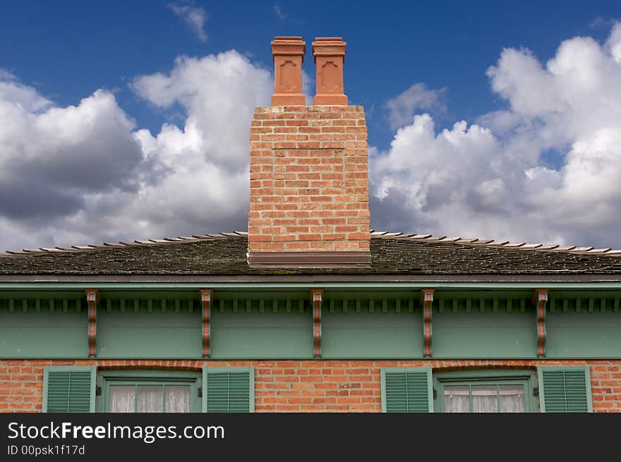 Classic Home Facade with a Dual Chimney dramatic clouds and blue skies