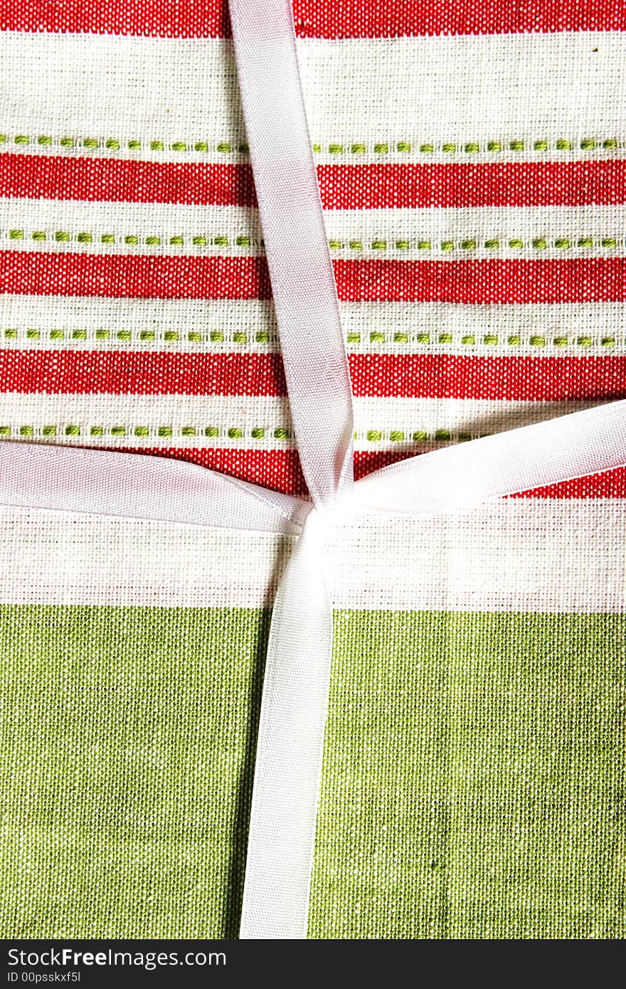 Close-up of a Christmas gift wrapped in fabric and ribbon - traditional red and green. Close-up of a Christmas gift wrapped in fabric and ribbon - traditional red and green.