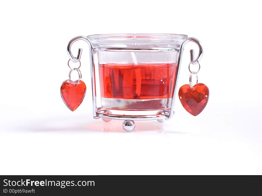 A bright red candle in glass with hearts. A bright red candle in glass with hearts