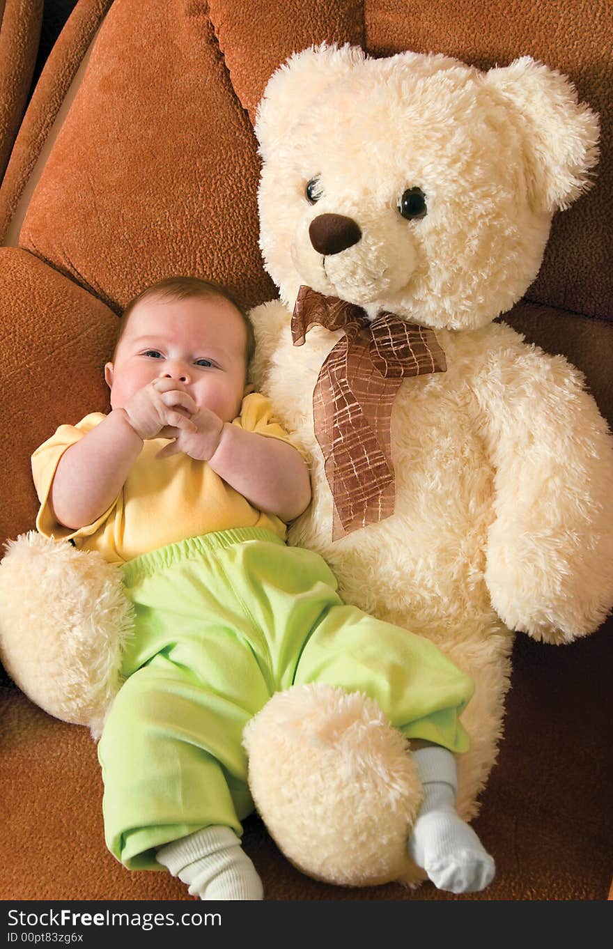 Relaxing small baby with a toy bear