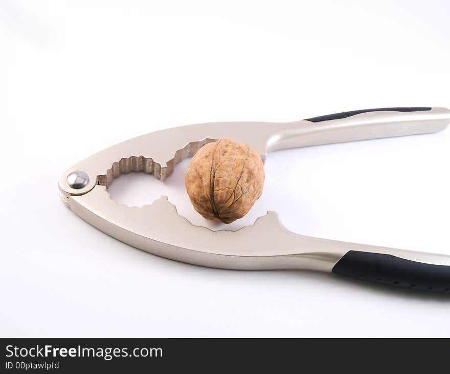 Walnut ready to be crushed by a nutcracker. Walnut ready to be crushed by a nutcracker