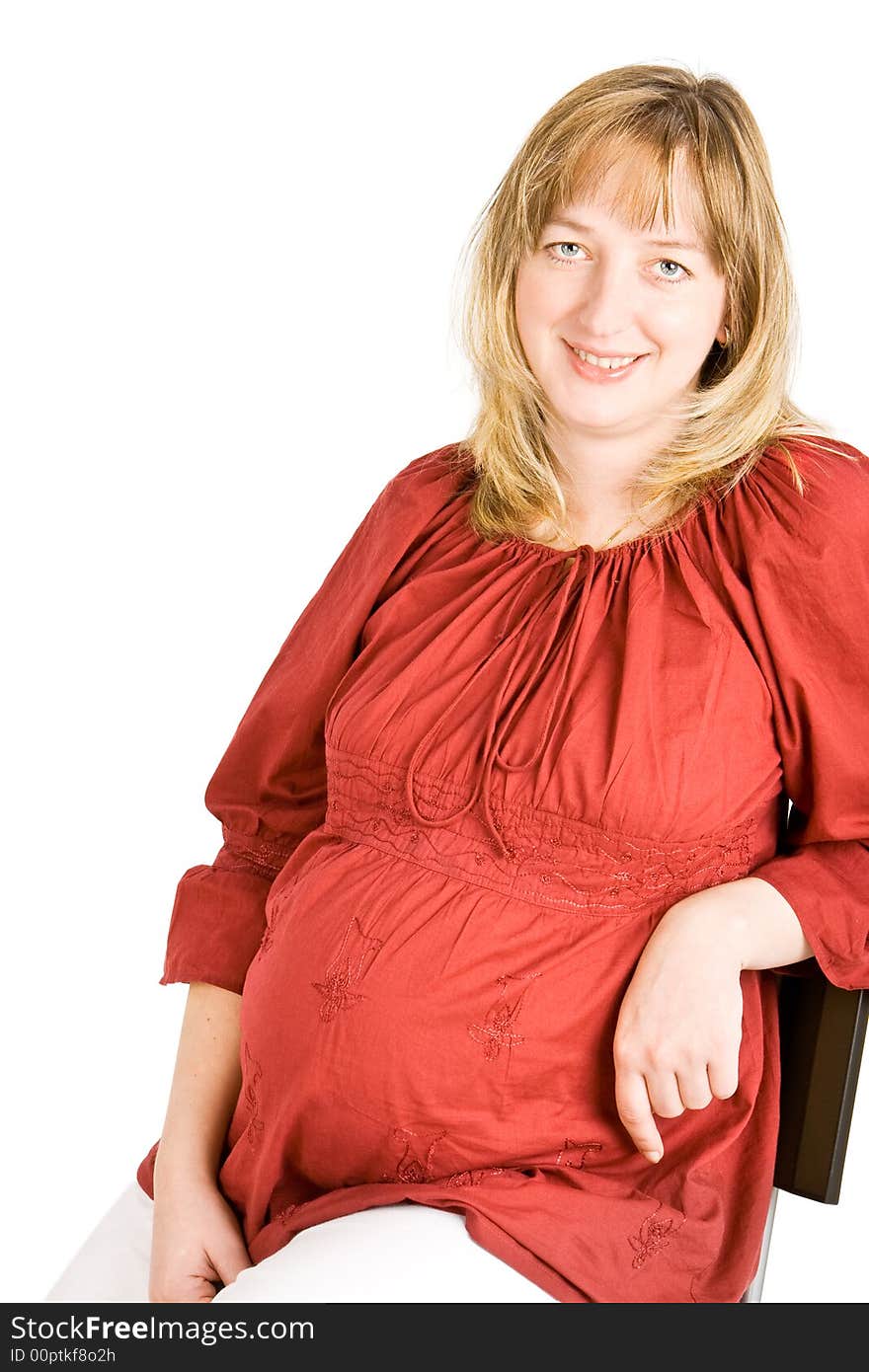 A pregnant lady smiling with a white background