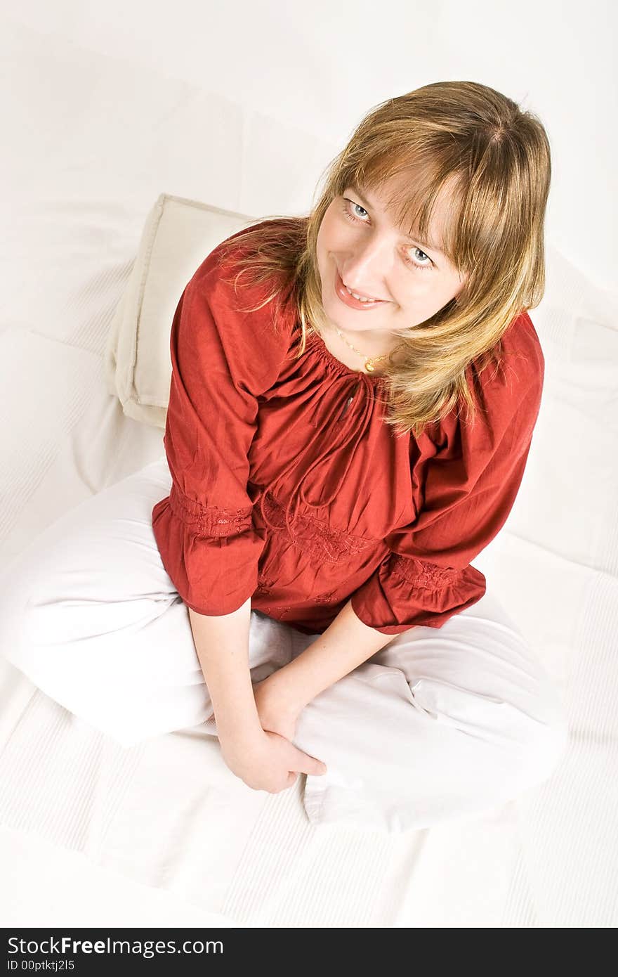 A pregnant lady in a red blouse smiling. A pregnant lady in a red blouse smiling