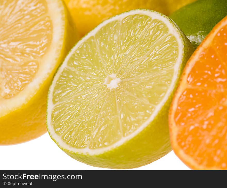 Set of slices of citrus fruits isolated on the white background. Focus on the lime slice. Set of slices of citrus fruits isolated on the white background. Focus on the lime slice.