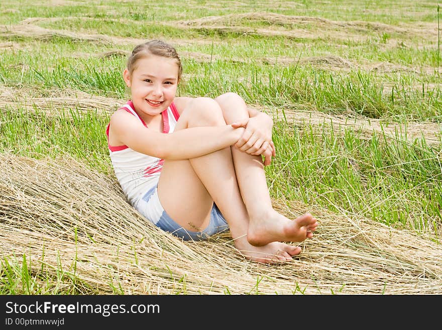 A pretty girl sitting in a field