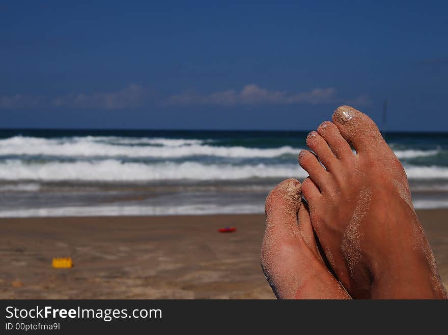 Female feet on back-ground sea in sand