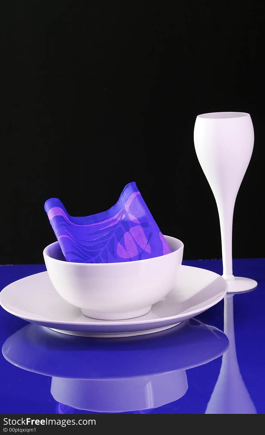 A modern table setting with plate and wine glass in blue and white. A modern table setting with plate and wine glass in blue and white