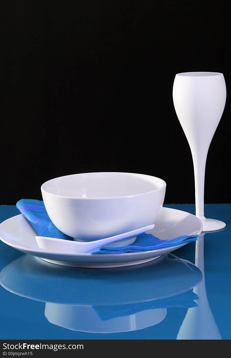 A contemporary dinning table set with plate, bowl and wine glass. A contemporary dinning table set with plate, bowl and wine glass