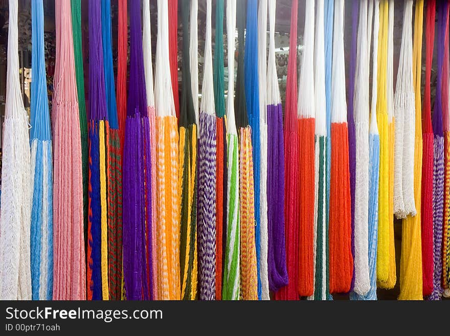 A rack of colorful rope hammocks at a flea market. A rack of colorful rope hammocks at a flea market