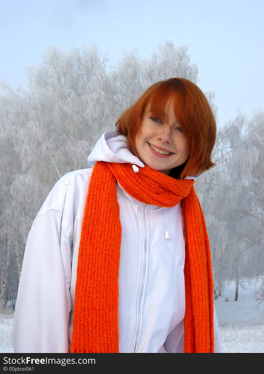 Red-haired girl with orange scarf at winter day