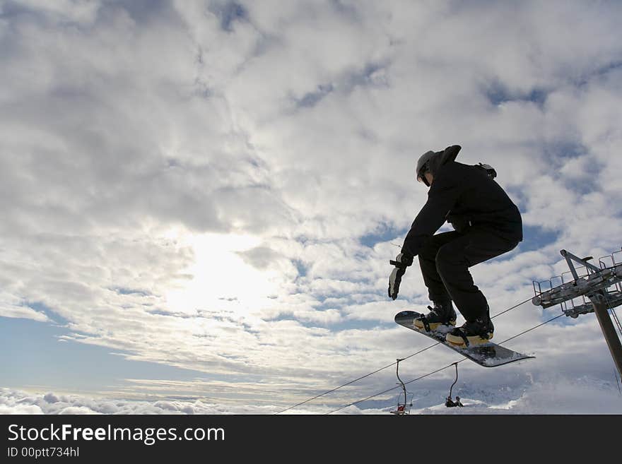 Snowboarder launching off a jump; horizontal orientation, afternoon light.