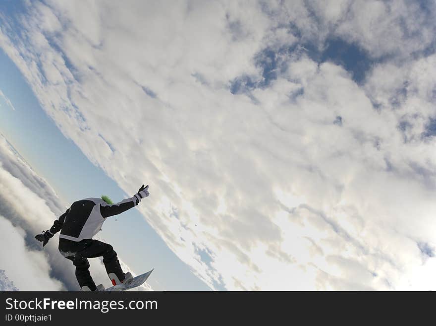 Snowboarder launching off a jump; horizontal orientation, afternoon light.