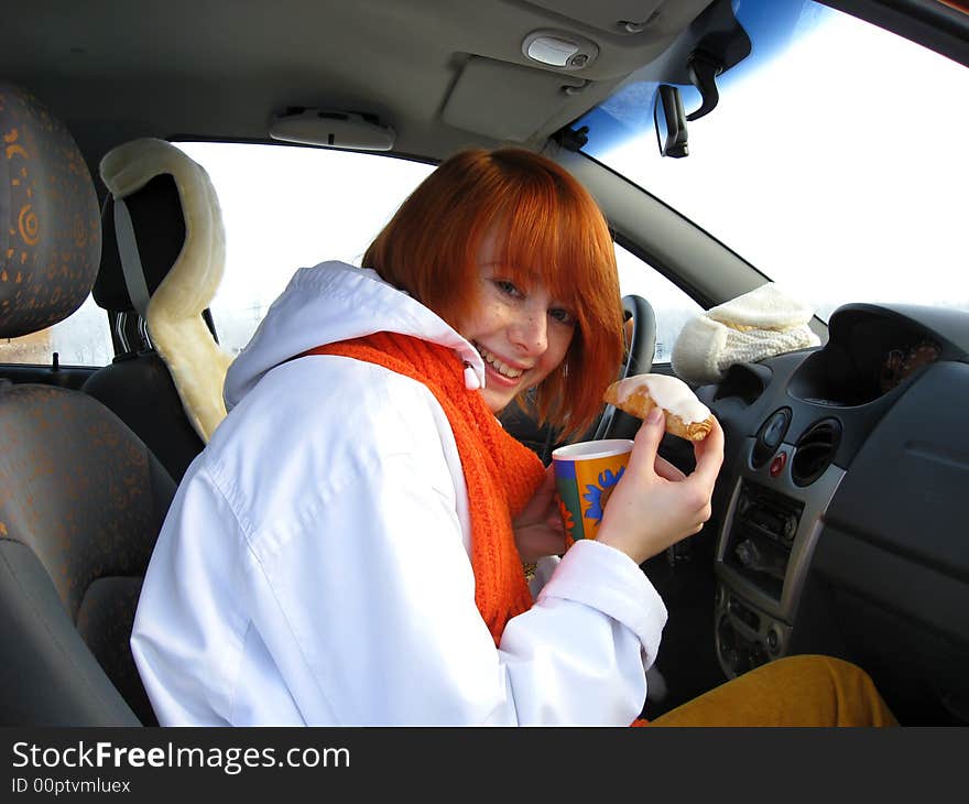 Red-haired girl with mug and sweet roll