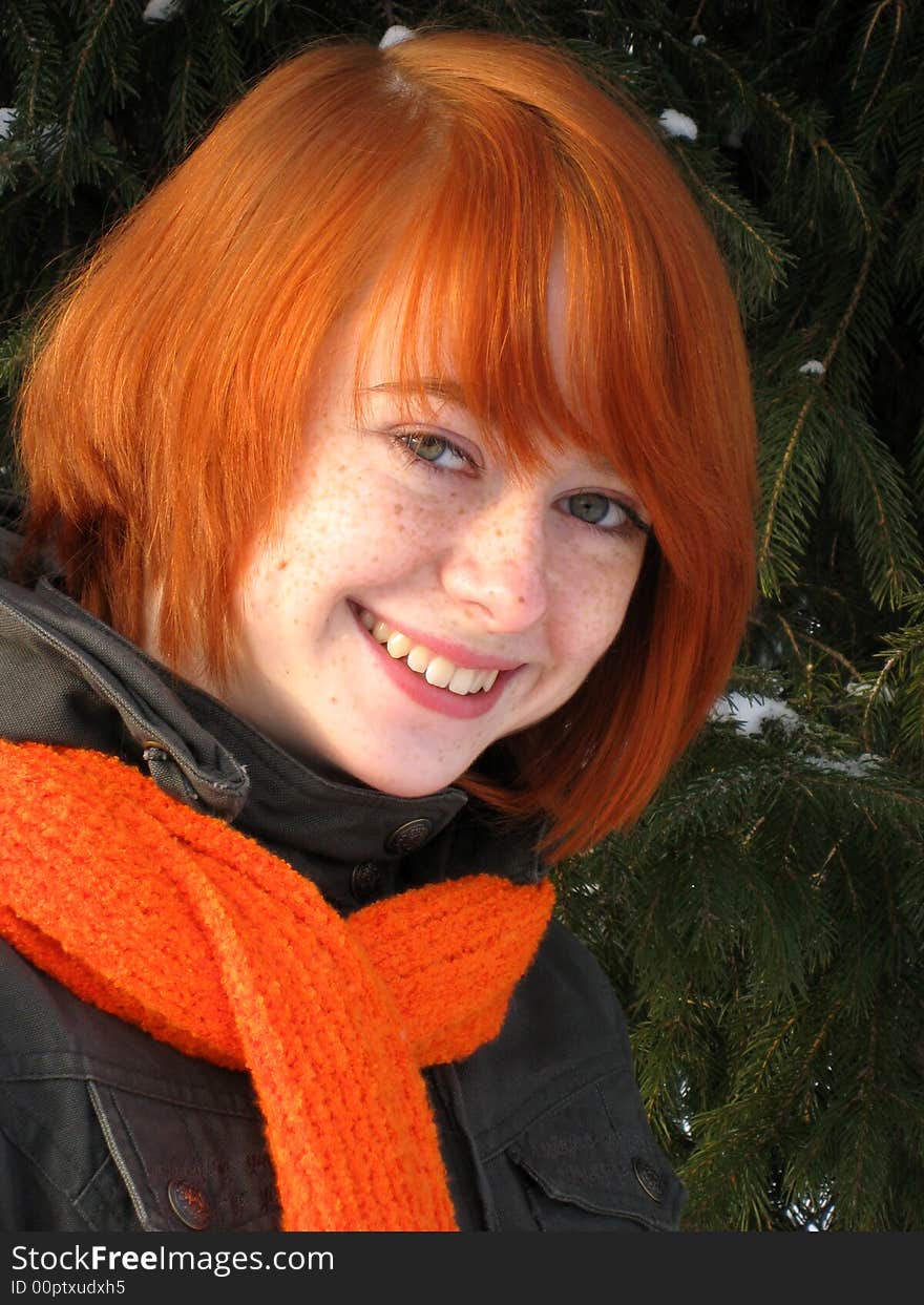 Red-haired girl with orange scarf and green fir