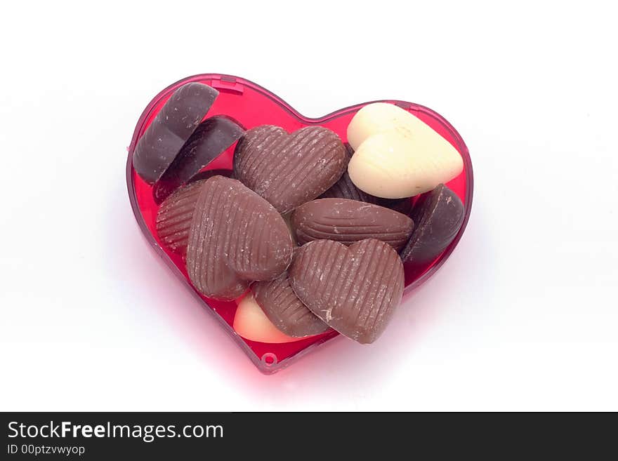 White and brown chocolates in a heart shaped box. White and brown chocolates in a heart shaped box