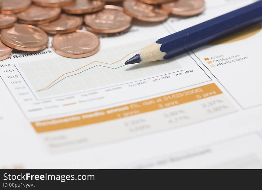 Coins, pencil and stock market graph