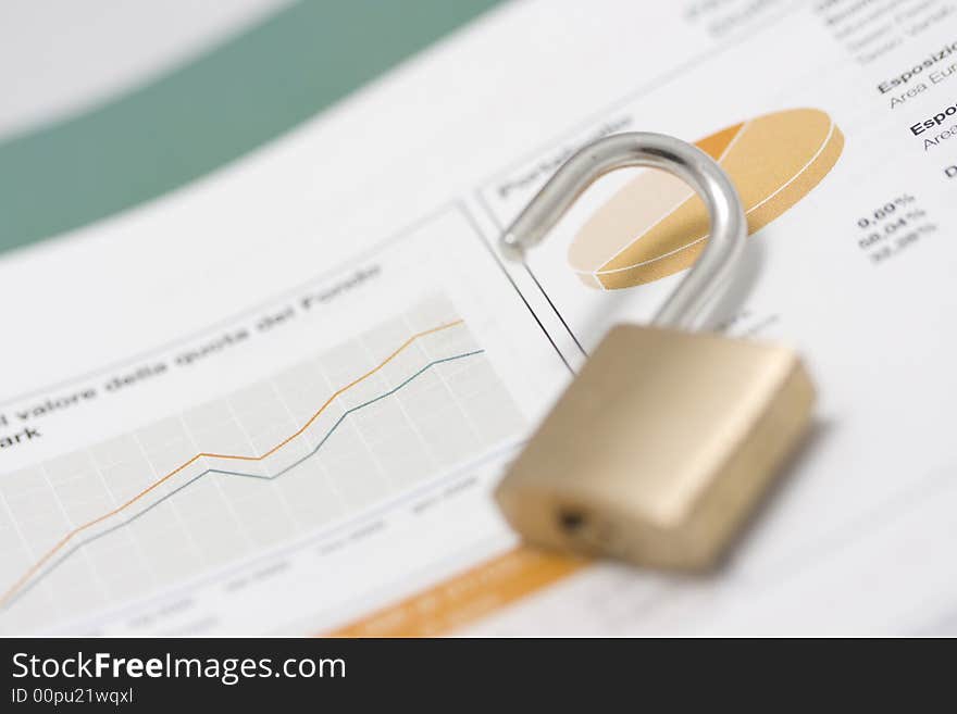 Stock market graph, portfolio and open padlock on top. Shallow depth of field, focus on graph line and pie-chart