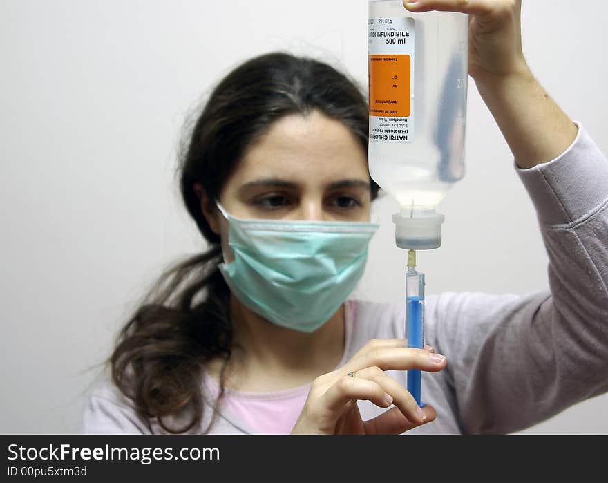 A girl, preparing the injection, wearing a mask. A girl, preparing the injection, wearing a mask